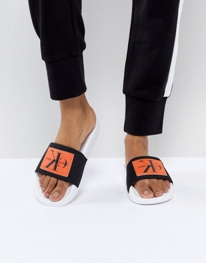 Calvin Klein Chloe Black and Orange Sliders | designer footbed slides - flipped