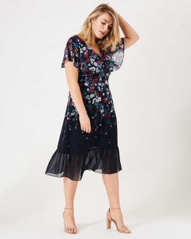 IMOGEN FLORAL PRINT DRESS | Studio8 | A stunning occasion style designed with a flattering fitted wrap bodice and a satin woven lining. Completed with a contemporary semi-sheer peplum hem and overlay sleeves - flipped