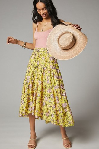 Anthropologie Clarabelle Maxi Skirt in yellow, with a pretty floral print is an essential addition to any spring and summer wardrobe. Featuring a drawstring waist and on-trend tiers, it can be worn with a strappy camisole, fresh white crop tee or even a cropped sweater. - flipped