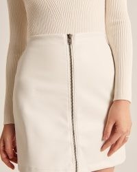 Abercrombie & Fitch Zip-Up Vegan Leather Mini Skirt White – on- trend faux leather skirts