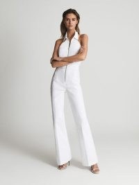 Reiss PENNIE Denim Halter Jumpsuit White | sleeveless halterneck summer jumpsuits | seventies inspired clothes | effortless 70s retro glamour