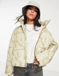Calvin Klein Jeans recycled polyester all over logo oversized puffer jacket in cream / women’s padded designer jackets / asos