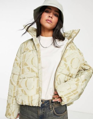 Calvin Klein Jeans recycled polyester all over logo oversized puffer jacket in cream / women’s padded designer jackets / asos