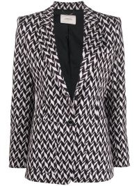 Taylor Swift’s black and white geometric print jacket, Dorothee Schumacher Chevron-Jacquard single-breasted blazer. Worn with a matching sleeveless high neck top and flared trousers, appearing on The Tonight Show with Jimmy Fallon, 24 October 2022 | celebrity blazers | star fashion