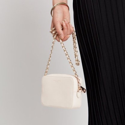 ASPINAL of LONDON Milly Bag in Smooth Ivory | small luxe camera bags | gold leather-plaited chain strap crossbody - flipped