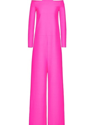 Olivia Culpo’s hot pink off the shoulder jumpsuit with sculpted neckline, Valentino Crepe Couture jumpsuit. Worn with a pair of patent platforms, long jersey gloves and carrying a leather mini sized top handle bag (all Valentino). Attending the ‘Forever Valentino’ Exhibition in Doha, Qatar, 27 October 2022 | celebrity red carpet outfits | star jumpsuits | designer fashion