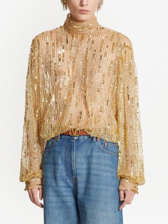 Nicky Hilton Rothchild’s gold sequinned high neck semi sheer top, Valentino Tulle Illusione sequin-embroidered blouse. Worn with a pair of blue denim flares and brown ankle strap platforms. On Instagram, 22 December 2022 | celebrity tops | social media fashion - flipped