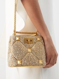 VALENTINO GARAVANI Roman Stud crystal-embellished handbag in gold – small luxury handbags – designer occasion bags – glamorous evening accessories – luxe event accessory