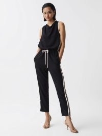 REISS TYLA SIDE STRIPE JUMPSUIT BLACK / women’s casual sleeveless sports inspired jumpsuits / womens all-in-one spotswear fashion / drawstring waist