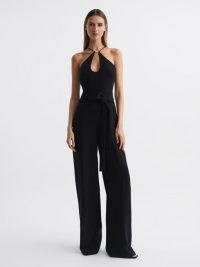 Reiss HALSTON EMA HALTER NECK WIDE LEG JUMPSUIT in BLACK / glamorous halterneck jumpsuits / chic 70s style all-in-one occasion clothes / women’s party fashion