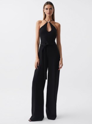 Reiss HALSTON EMA HALTER NECK WIDE LEG JUMPSUIT in BLACK / glamorous halterneck jumpsuits / chic 70s style all-in-one occasion clothes / women’s party fashion - flipped