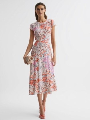 Reiss LUNA FLORAL PRINT CAP SLEEVE DRESS is a stunning piece of women’s fashion that has been designed and crafted with great care and attention to detail. This dress is a perfect example of the quality and elegance that Reiss is known for, and it is sure to make any woman feel beautiful and confident. At first glance, the dress appears to be a simple and classic design, but upon closer inspection, it is clear that every aspect of this dress has been carefully considered. The floral print, for example, is a work of art. The intricate design features a variety of different flowers, all of which have been beautifully arranged to create a stunning overall effect. The print is both bold and delicate, with bright pops of color interspersed with more subtle tones. The cap sleeves of the dress are another standout feature. They provide just the right amount of coverage for the arms while still allowing for a breezy and comfortable fit. The sleeves are cut in a way that is both flattering and feminine, with a slight gather at the top that creates a soft and romantic look. The shape of the dress is also noteworthy. It is cut to be fitted at the waist and then flares out gently to create a flattering A-line silhouette. This shape is both elegant and timeless, and it is sure to flatter a variety of different body types. The dress is also designed to be worn at knee length, making it a versatile option that can be worn to a variety of different events. When it comes to materials, Reiss has spared no expense. The dress is made from a high-quality silk blend that feels incredibly soft and luxurious against the skin. This material has a slight sheen to it that catches the light beautifully, adding to the overall elegance of the dress. In terms of styling, the Reiss LUNA FLORAL PRINT CAP SLEEVE DRESS is a versatile piece that can be dressed up or down depending on the occasion. For a more formal event, it can be paired with a pair of heels and some statement jewelry to create a sophisticated and polished look. For a more casual occasion, it can be paired with a pair of sandals and a denim jacket for a more relaxed and effortless vibe. Overall, the Reiss LUNA FLORAL PRINT CAP SLEEVE DRESS is a stunning piece of women’s fashion that is sure to make a statement. Its attention to detail, high-quality materials, and classic design make it a versatile piece that can be worn to a variety of different events. Whether you’re looking for a dress to wear to a wedding, a graduation, or a summer garden party, the Reiss LUNA FLORAL PRINT CAP SLEEVE DRESS is sure to be a perfect choice. - flipped