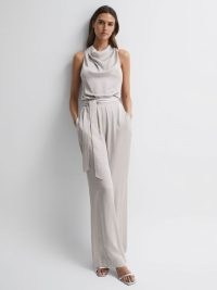 REISS ROSE SLEEVELESS COWL NECK JUMPSUIT in NEUTRAL – chic evening jumpsuits – sophisticated occasion clothes – elegant all-in-one party fashion – self tie waist belt
