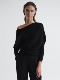 Reiss LORNA ASYMMETRIC DRAPE KNITTED TOP in BLACK | women’s tops with an asymmetrical neckline | chic knitwear clothing