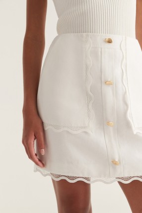 Aje. Reva Wave Trim Skirt in Ivory – luxe off white scallop trimmed mini skirts - flipped